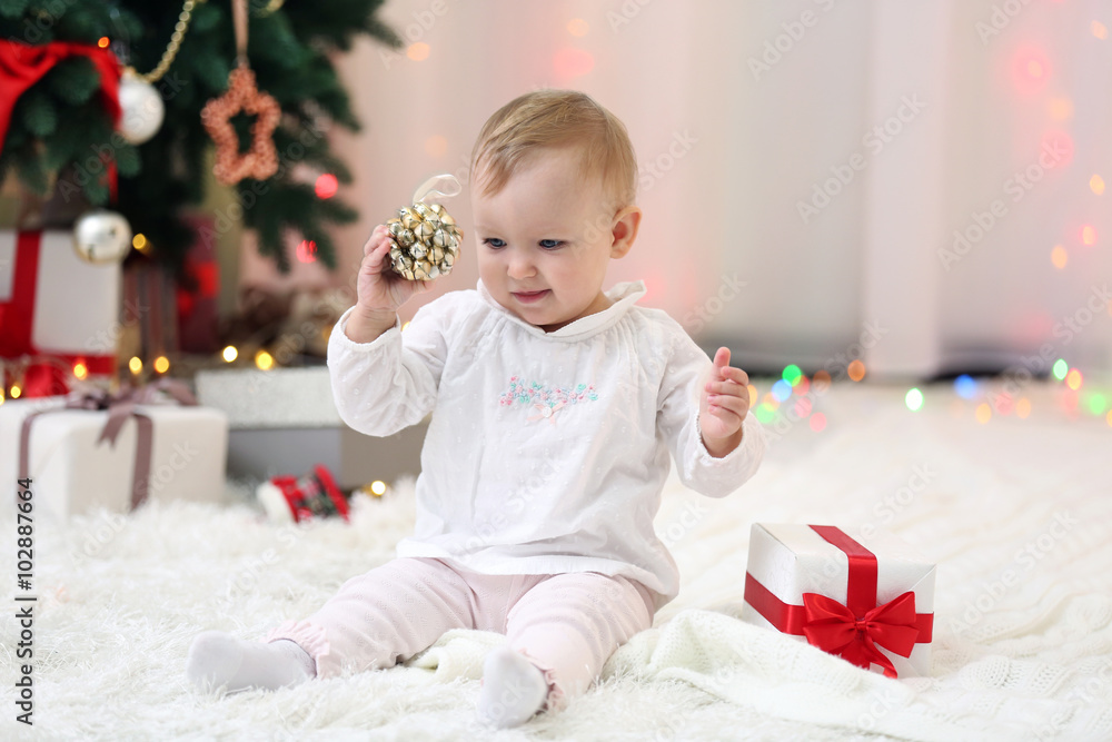 Funny baby girl with gift boxes and Christmas tree on background Funny baby girl with gift boxes and Christmas tree on background