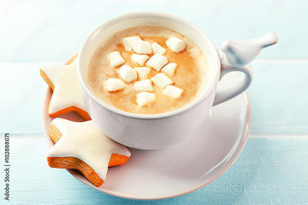 Cup of hot cacao with marshmallow and cookies on blue table Cup of hot cacao with marshmallow and cookies on blue table