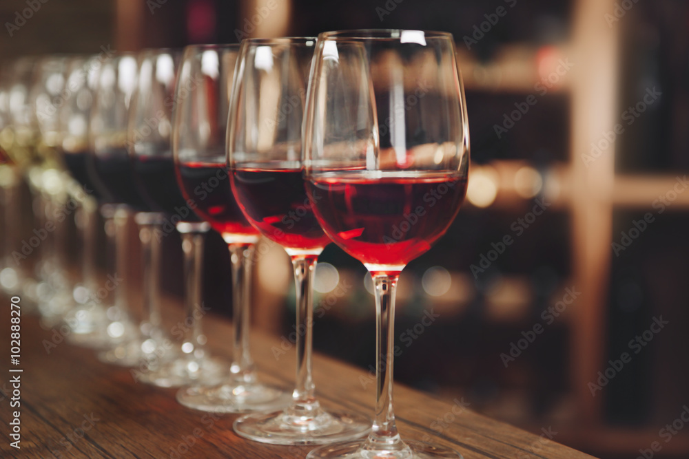 Many glasses of different wine in a row on bar counter