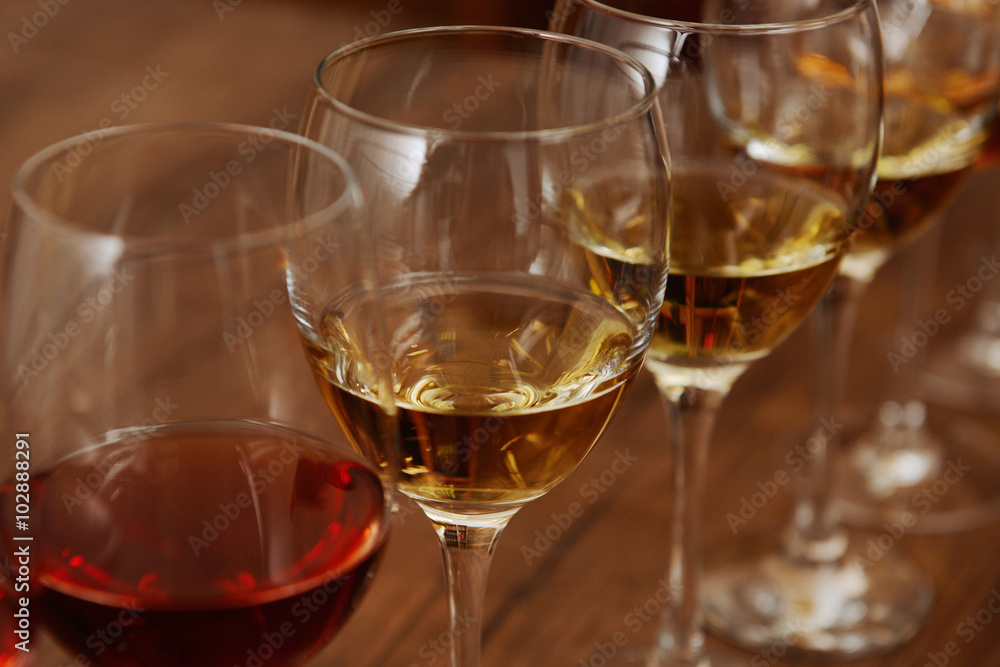 Many glasses of different wine in a row on bar counter, close up Many glasses of different wine in a row on bar counter, close up