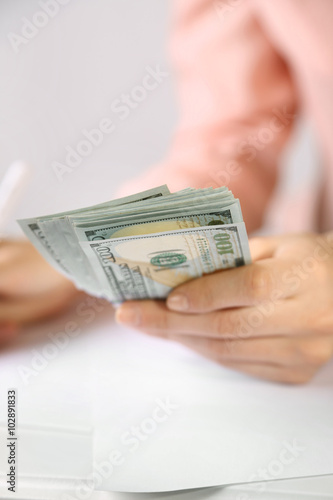 Hand holding dollar banknotes on white background