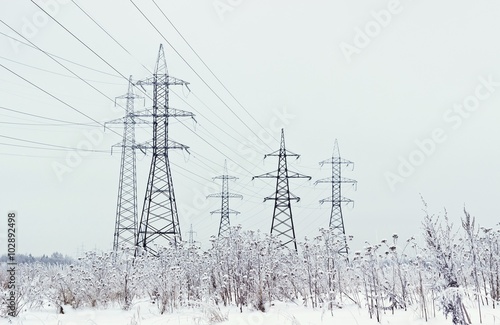Electricity towers in winter. Blurred foreground