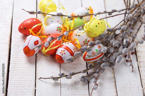 Decorative Eeaster eggs and willow branches on wooden background photo