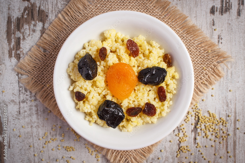 Cooked millet groats on white plate, healthy food and nutrition Cooked millet groats on white plate, healthy food and nutrition
