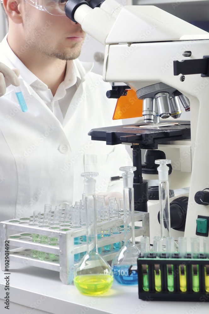 Young scientist studying new substance or virus in microscope Young scientist studying new substance or virus in microscope