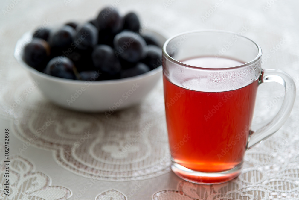 cup of compote and frozen plums on the table cup of compote and frozen plums on the table