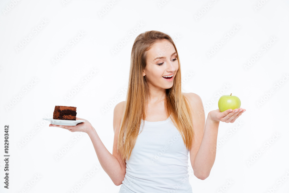 Cheerful woman choosing between healthy and unhealthy food Cheerful woman choosing between healthy and unhealthy food