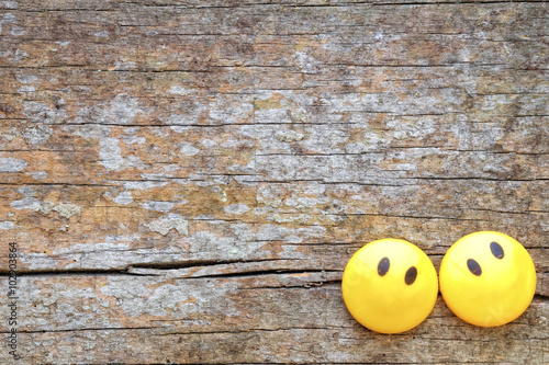 Wooden background with yellow face in the corner