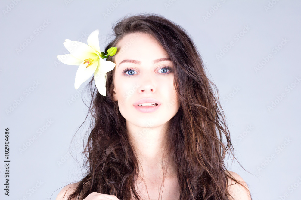 Woman with curly hair and big blue eyes. Woman with a flower in her hair. Woman with curly hair and big blue eyes. Woman with a flower in her hair.