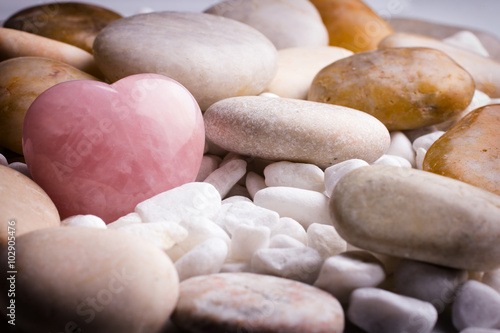 Pink heart stone on the spa stone background.