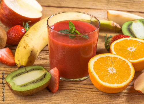 Bild auf Leinwand natural strawberry smoothie surrounded by fruit on wooden base