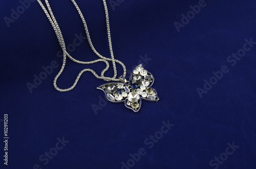 Silver butterfly fashion jewelry with rhinestones on blue velvet background