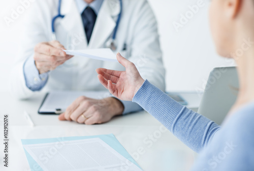Doctor giving a medical prescription to the patient photo