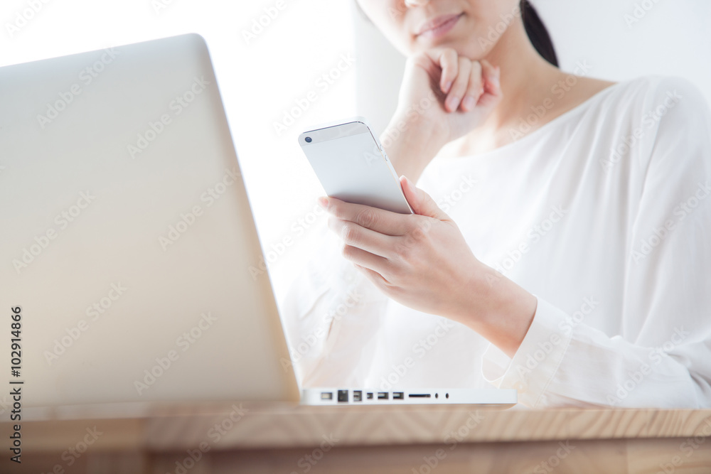 携帯電話でインターネットをする女性 ラップトップ ノートパソコン 携帯電話でインターネットをする女性 ラップトップ ノートパソコン