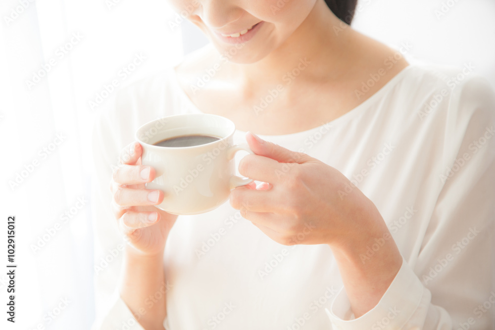 コーヒーを飲む女性 笑顔 窓際 コーヒーを飲む女性 笑顔 窓際