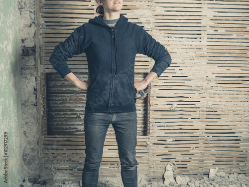 Woman wih hammer by wattle and daub wall