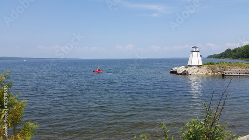 Lighthouse and red canoe in scenic view of Manitoulin island. Canada.