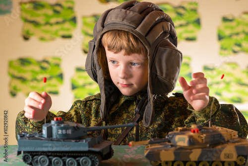 Boy playing toy military tank