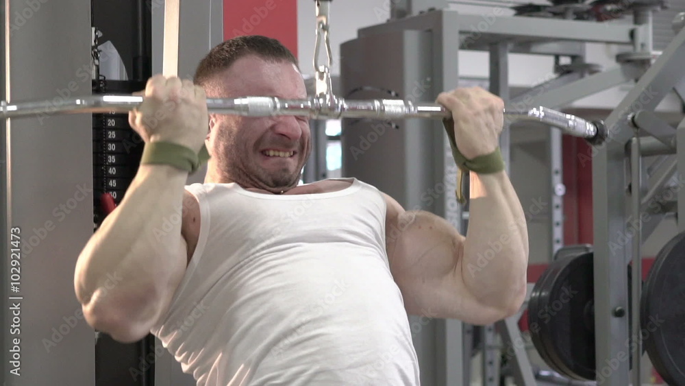 The champion of bodybuilding making hard exercise for arms and shoulders. Slowly The champion of bodybuilding making hard exercise for arms and shoulders. Slowly