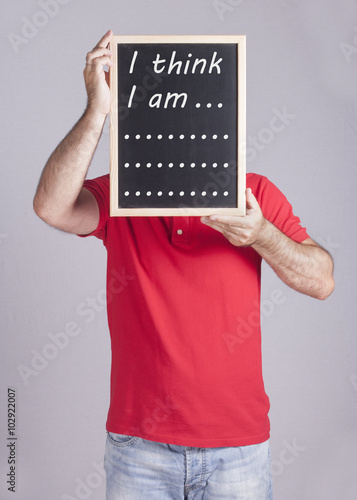 Man holding I Think I am... message written on a blackboard photo