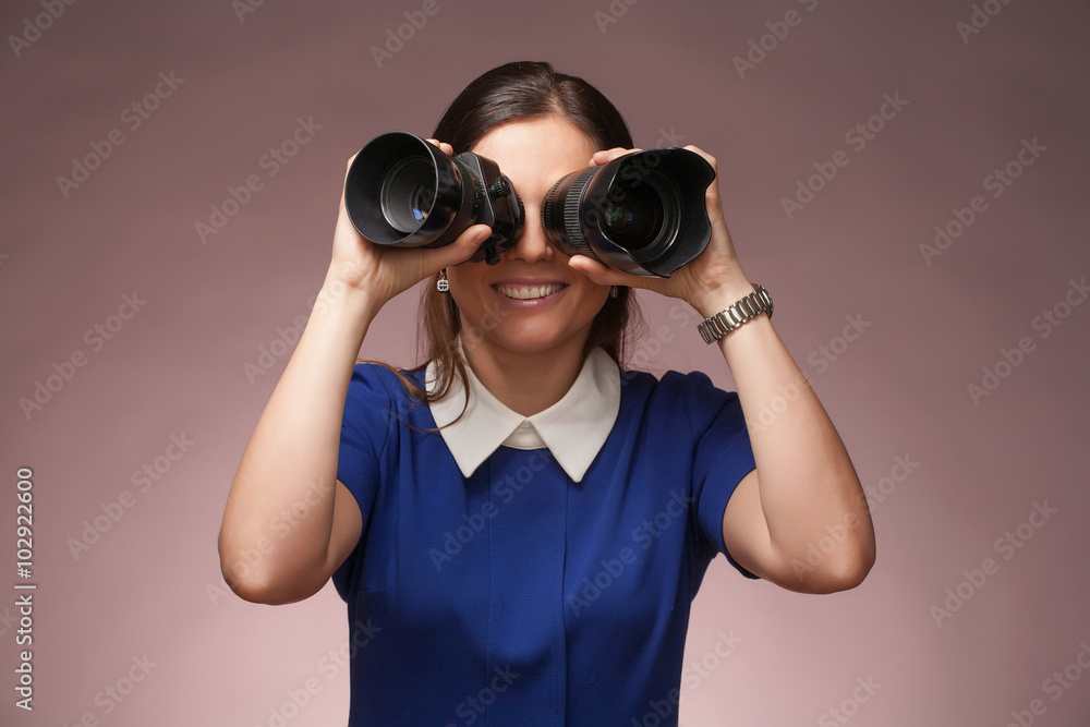 Girl in a blue suit. Makes binocular by two photo lenses. Girl in a blue suit. Makes binocular by two photo lenses.