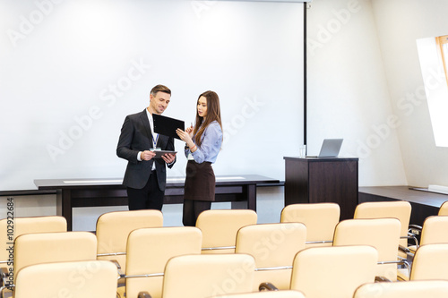 Businessman and businesswoman working in meeting hall