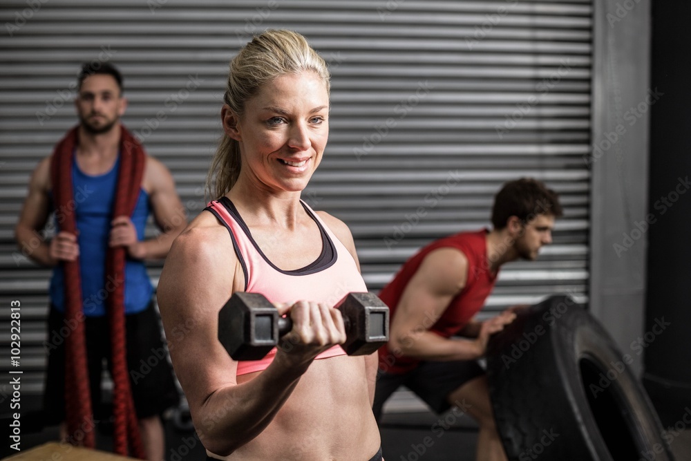 Portrait of fit woman lifting dumbbells