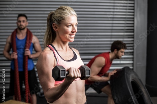 Portrait of fit woman lifting dumbbells