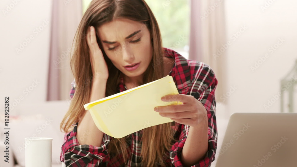 Upset brunette with calculator paying bills Upset brunette with calculator paying bills