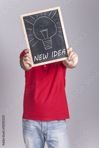 Man holding New Idea message written on a blackboard photo