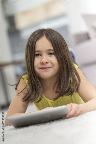 little girl with table pc at home photo