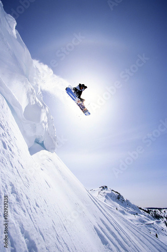 Snowboarder flying with mountains