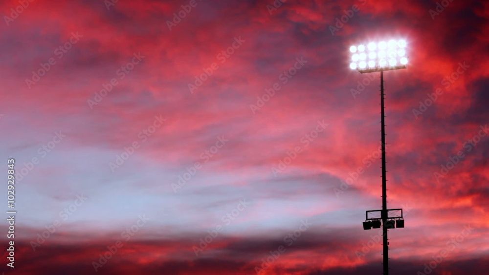 Beautiful pink and purple sky behind one floodlight in a stadium. Beautiful pink and purple sky behind one floodlight in a stadium.