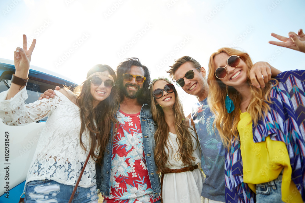 Fototapeta premium hippie friends over minivan car showing peace sign