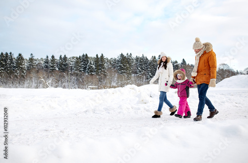 happy family in winter clothes walking outdoors