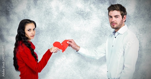 Composite image of portrait of couple holding red cracked heart  photo