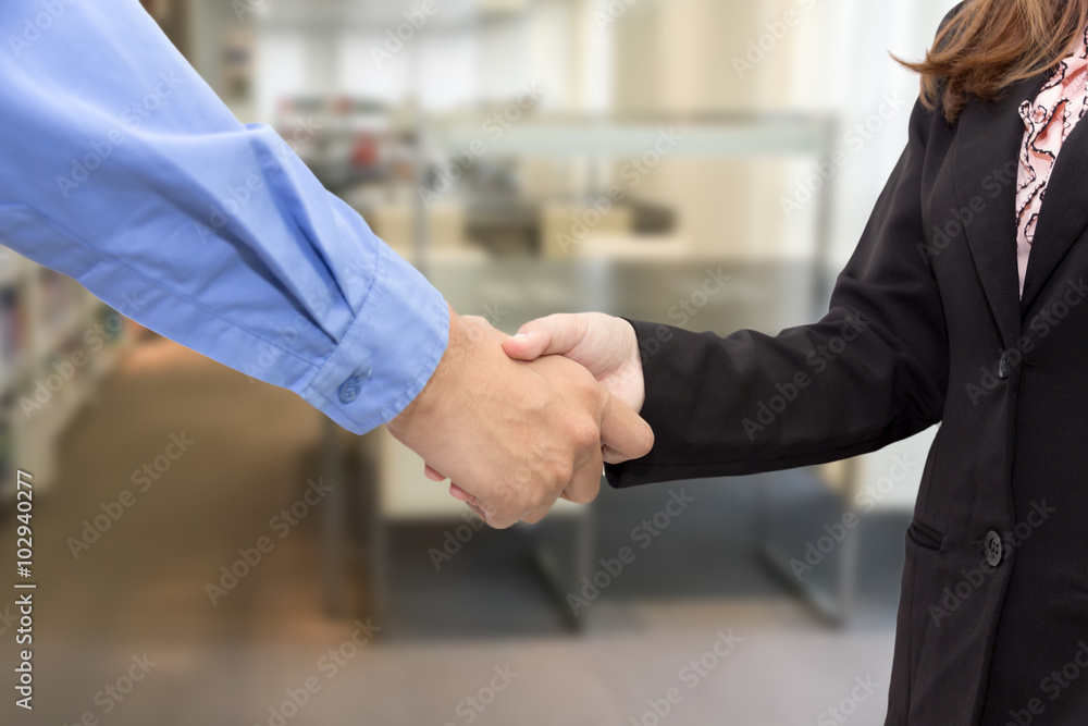 Fototapeta premium Close up of businessmen shaking hands in library