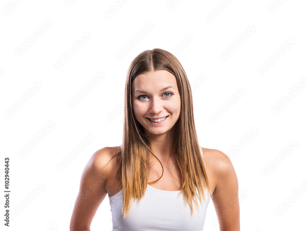 Smiling teenage girl wearing a tight white singlet, isolated Smiling teenage girl wearing a tight white singlet, isolated