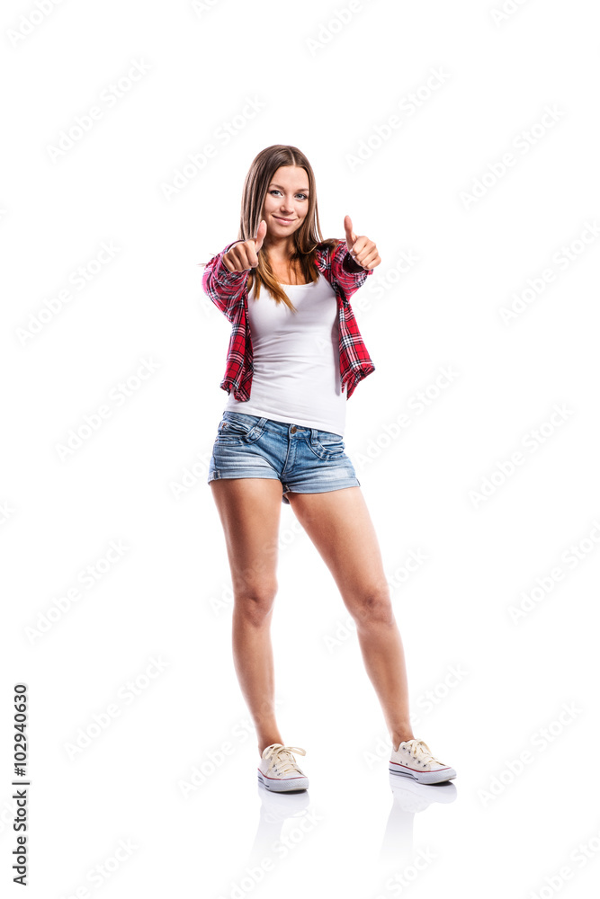Girl in shorts and checked shirt, thumbs up, isolated Girl in shorts and checked shirt, thumbs up, isolated
