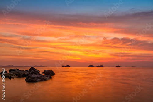 Colored sunset over the tropical sea, stones and cliffs 