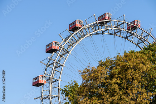 Fun Park Ferris Wheel Against Blue Sky In Vienna Prater Park