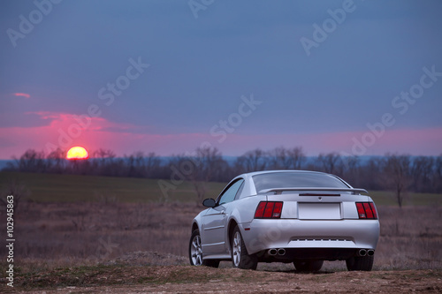 Car stay on dirt road at sunset