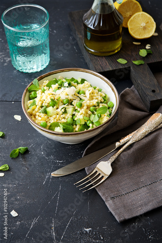 Pasta salad (fregola) with green peas, cucumber, lemon and mint in the bowl 
 