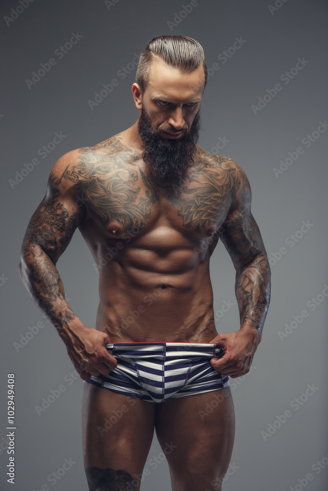 Fototapeta premium Naked bearded man with tattooed body.