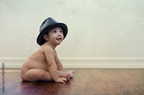 Baby Smile With Hat / Infant sitting nude baby smiling looking up and wearing a hat.