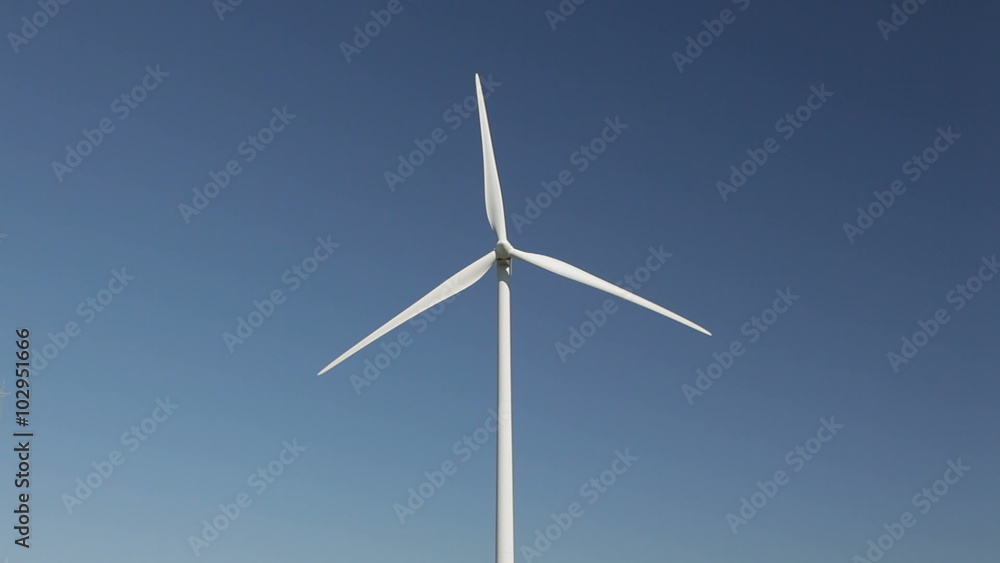Wind turbine spinning with a blue sky as background Wind turbine spinning with a blue sky as background