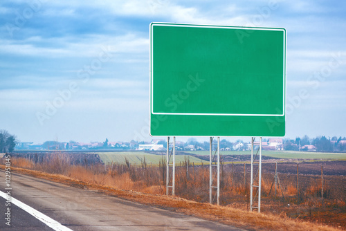 Фотография Blank traffic road sign by the roadway