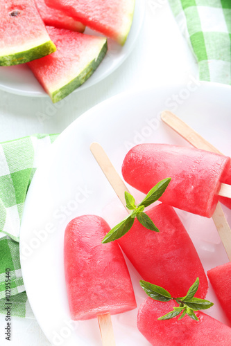 Watermelon popsicle on plate on white wooden table