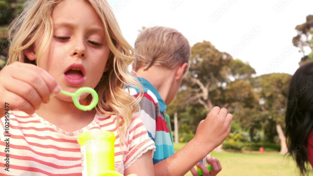 Happy children blowing bubbles
