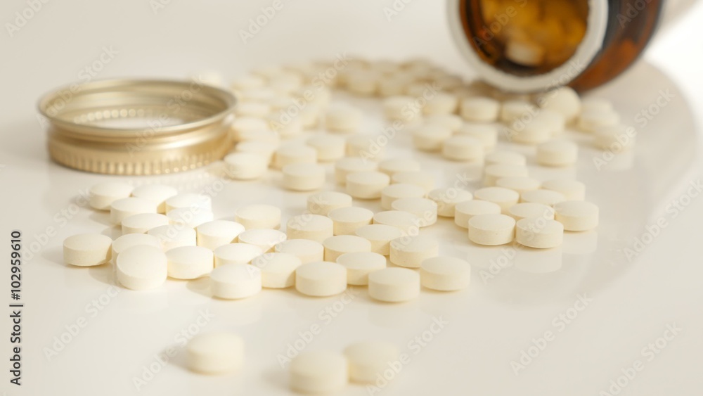 Bottle of pills spilled on reflective white surface 4K 2160p 30fps UltraHD video - Plastic container with tablets on white background slow tilt 4K 3840X2160 UHD footage Bottle of pills spilled on reflective white surface 4K 2160p 30fps UltraHD video - Plastic container with tablets on white background slow tilt 4K 3840X2160 UHD footage